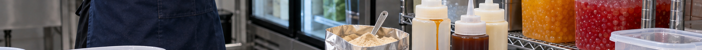 A shop manager reviews bubble tea ingredient storage for powders, syrups, tea leaves, and popping boba.